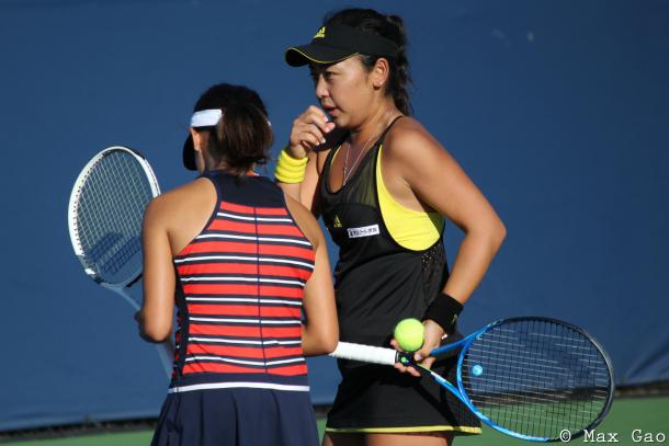 Eri Hozumi (in black) and Miyu Kato discuss strategy before the former serves during their first-round match at the 2017 Rogers Cup presented by National Bank. | Photo: Max Gao