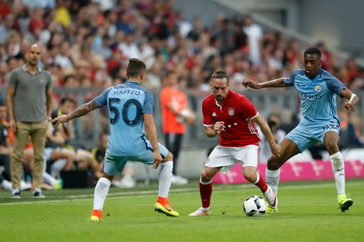 Franck Ribéry with the ball as his former boss watches on. | Photo: Manchester Evening News