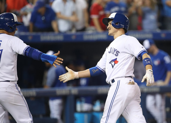 Darwin Barney (R) is congratulated by Ryan Goins after hitting a two-run homer in the bottom of the sixth inning to get the Blue Jays to draw first blood. | Photo: Photo: Tom Szczerbowski/Getty Images