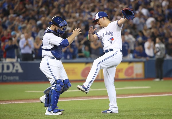 Roberto Osuna and Russell Martin celebrate after Osuna clinched his career-high 37th save of the season. | Photo: Tom Szczerbowski/Getty Images