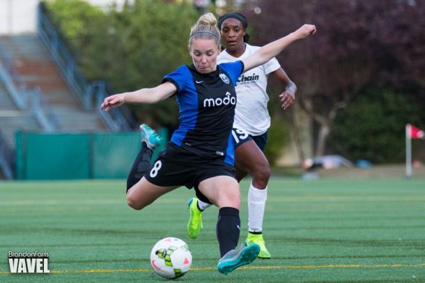 Seatle Reign midfielder Kim Little takes a shot during a game against the Washington Spirit. Forward Crystal Dunn looks on in the background / Brandon Farris - VAVEL USA