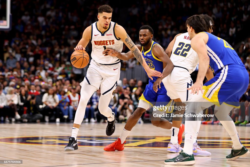 Michael Porter Jr. #1 of the Denver Nuggets drives against Andrew Wiggins #22 of the Golden State Warriors at Ball Arena on December 25, 2023 in Denver, Colorado. NOTE TO USER: User expressly acknowledges and agrees that, by downloading and/or using this Photograph, user is consenting to the terms and conditions of the Getty Images License Agreement. (Photo by Jamie Schwaberow/Getty Images)