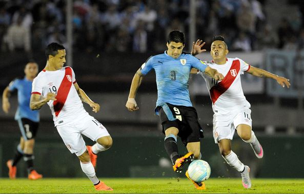 Luis Suarez of Uruguay (C) fights for the ball with Yoshimar Yotun and Christian Cueva of Peru during a match between Uruguay and Peru as part of FIFA 2018 World Cup Qualifiers at Centenario Stadium | Sandro Preyra - LatinContent/Getty Images