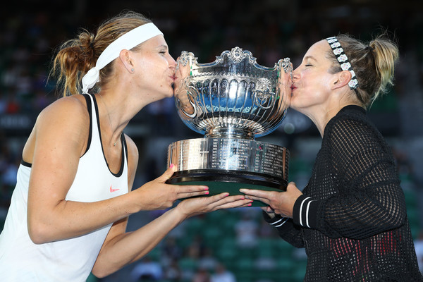 Lucie Safarova (L) and Bethanie Mattek-Sands kiss the winners’ doubles trophy after claiming the 2017 Australian Open title, the fourth Grand Slam title of their partnership. | Photo: Clive Brunskill/Getty Images