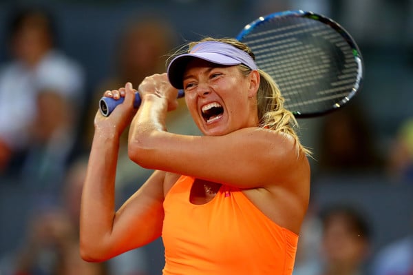 Maria Sharapova hits a backhand, coupled with her famous grunt | Photo: Clive Rose/Getty Images Europe