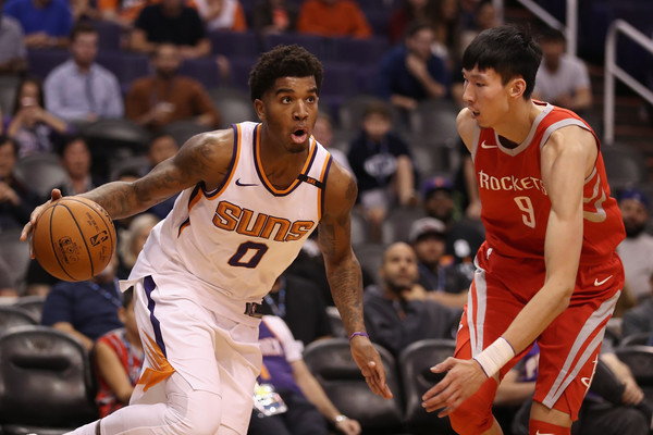 Marquese Chriss #0 of the Phoenix Suns moves the ball past Zhou Qi #9 of the Houston Rockets on November 16, 2017 in Phoenix, Arizona. The Rockets defeated the Suns 142-116. |Christian Petersen/Getty Images North America|