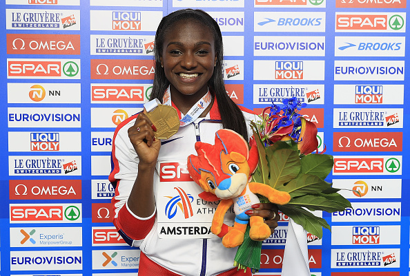 Dina Asher-Smith smiles for the cameras after receiving her gold medal for her 200 metres victory at the European Championships (Getty/Matthew Lewis)