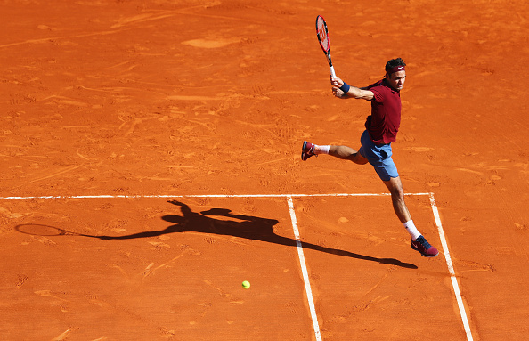 Federer leaps as he sends a backhand down the line for a winner against Tsonga. Credit: Michael Steele/Getty Images