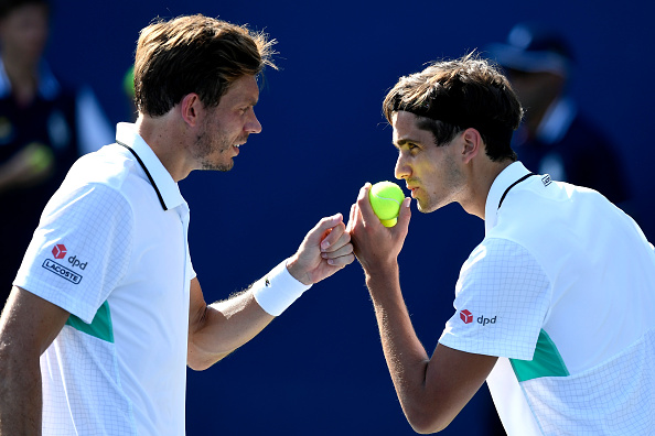 Pierre-Hugues Herbert and Niolas Mahut talk in between points (Photo: Sarah Stier/Getty Images)