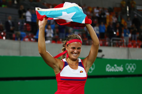 An ecstatic Monica Puig does a victory lap with the Puerto Rican flag after becoming the nation’s first Olympic gold medallist. | Photo: Clive Brunskill/Getty Images