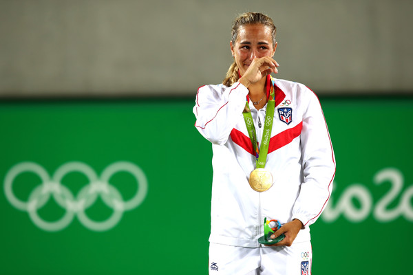 An emotional Monica Puig listens to the Puerto Rican national anthem after becoming the island’s first Olympic gold medallist. | Photo: Clive Brunskill/Getty Images