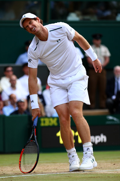 Andy Murray shows his pain and leans on his racquet for support during his quarterfinal loss at Wimbledon, largely hampered by a hip injury. Photo: Clive Brunskill/Getty Images