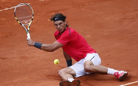 Nadal returns a shot despite falling during the 2012 French Open final. Photo: AFP/Getty Images