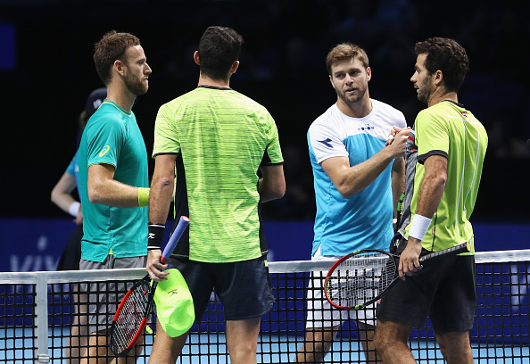 Jean-Julien Rojer and Horia Tecau shake hands with the group winners Ryan Harrison and Michael Venus (Photo: Julian Finney/Getty Images)