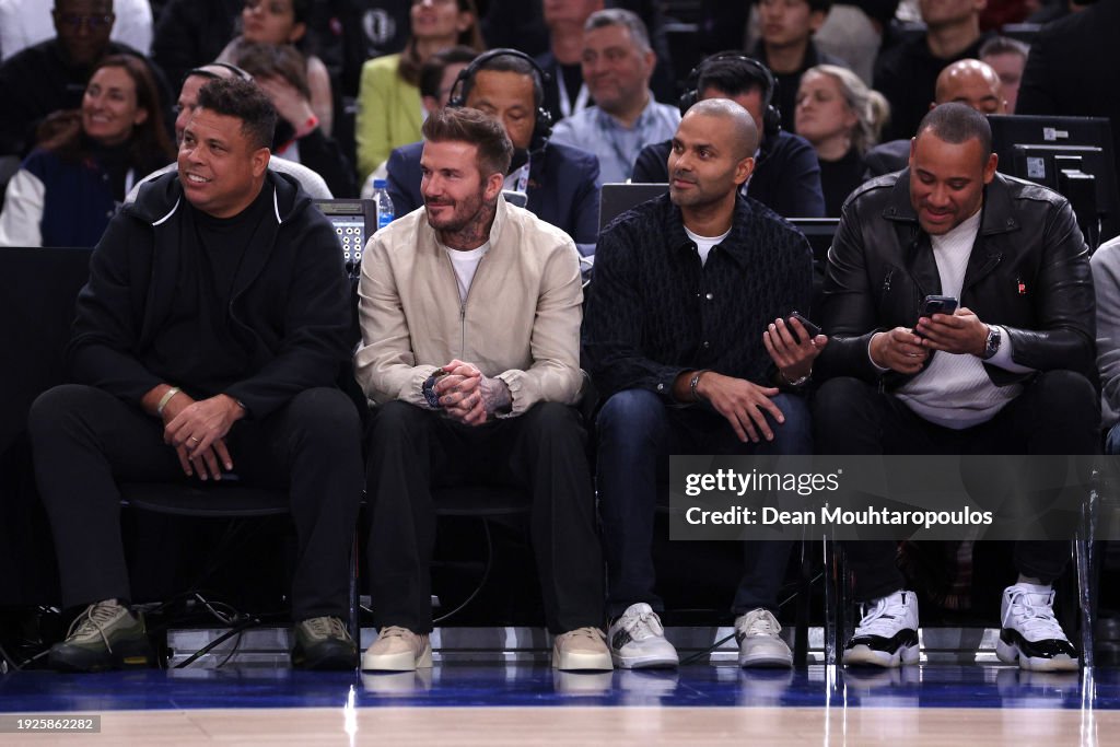 Former football players, David Beckham of England, Ronaldo of Brazil #R9 and Tony Parker look on during NBA match between Brooklyn Nets and Cleveland Cavaliers at The Accor Arena on January 11, 2024 in Paris, France. (Photo by Dean Mouhtaropoulos/Getty Images