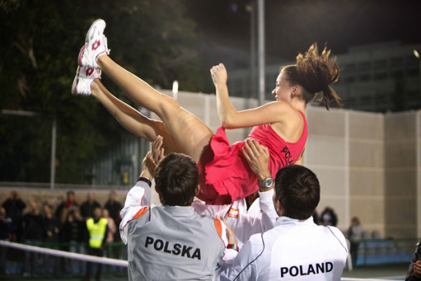 Agnieszka Radwanska is hoisted into the air by her teammates in celebration. Photo: Fed Cup