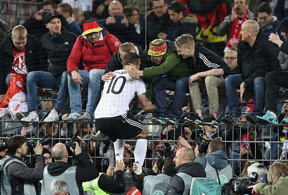 Podolski sobe no "alambrado" para abraçar os torcedores (Foto: Maja Hitij/Boogarts/Getty Images)