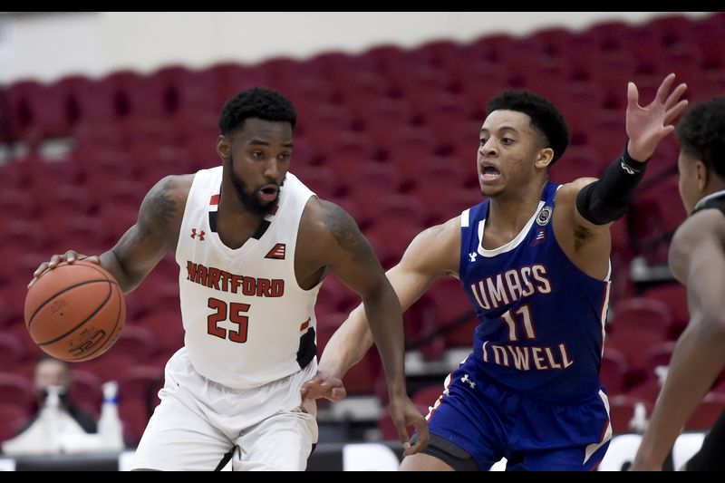 Hartford's Traci Carter (l.) driver past UMass-Lowell's Obadiah Noel (r.) during the America East championship game/Photo: Kassi Jackson/Hartford Courant