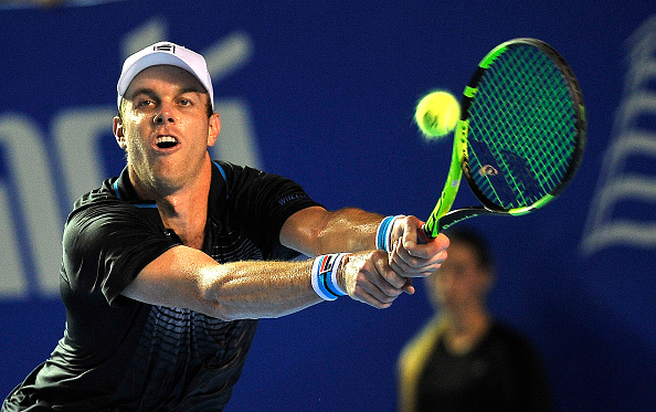 Sam Querrey stretches for a backhand. Photo: Pedro Pardo/AFP/Getty Images