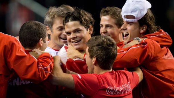 Milos Raonic is embraced by his team after their upset of Spain in 2013. Photo: Darryl Dyck/Canadian Press