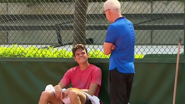Raonic (seated) and McEnroe talk during a practice in Paris. Photo: TSN