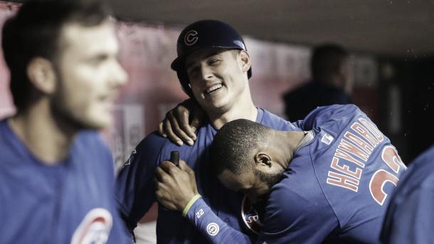 Chicago Cubs' Anthony Rizzo, center, celebrates in the dugout with Jason Heyward after hitting a solo home run off Cincinnati Reds starting pitcher Jon Moscot during the fourth inning  Friday, April 22, 2016, in Cincinnati. (John Minchillo / AP) 