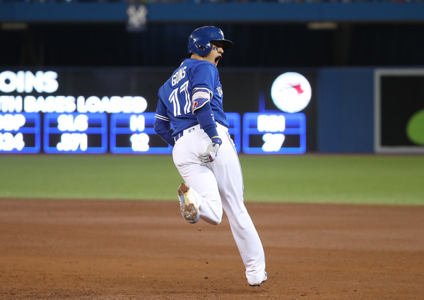 Ryan Goins celebrates while circling the bases after hitting his second-career Grand Slam in the sixth inning to extend Toronto’s lead to 8-1. | Photo: Tom Szczerbowski/Getty Images