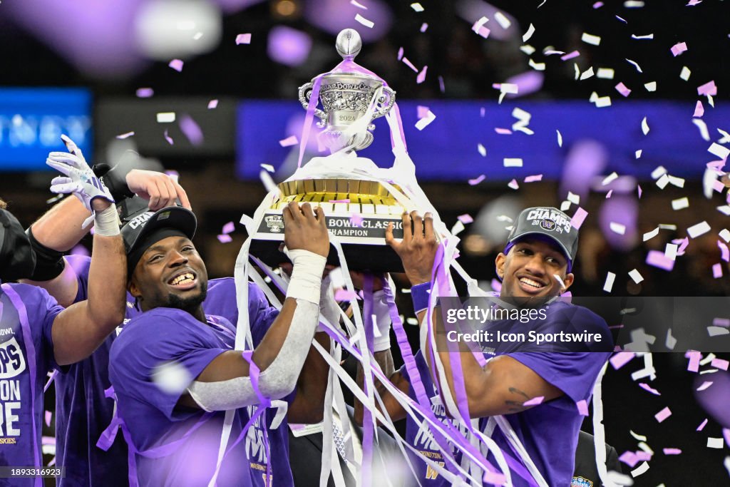  Washington Huskies defensive end Bralen Trice (8) and Washington Huskies quarterback Michael Penix Jr. (9) raise the trophy for winning the Semifinal All State Sugar Bowl football game between the Texas Longhorns and Washington Huskies at the Caesars Superdome on January 1, 2024 in New Orleans Louisiana. (Photo by Ken Murray/Icon Sportswire via Getty Images)