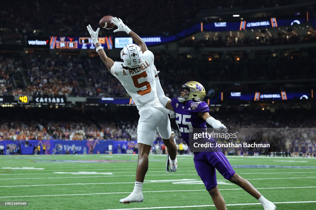 Adonai Mitchell #5 of the Texas Longhorns catches a touchdown pass against Elijah Jackson #25 of the Washington Huskies during the fourth quarter during the CFP Semifinal Allstate Sugar Bowl at Caesars Superdome on January 01, 2024 in New Orleans, Louisiana. (Photo by Jonathan Bachman/Getty Images)