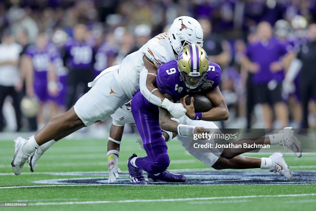 Justice Finkley #1 of the Texas Longhorns tackles Michael Penix Jr. #9 of the Washington Huskies during the third quarter during the CFP Semifinal Allstate Sugar Bowl at Caesars Superdome on January 01, 2024 in New Orleans, Louisiana. (Photo by Jonathan Bachman/Getty Images)