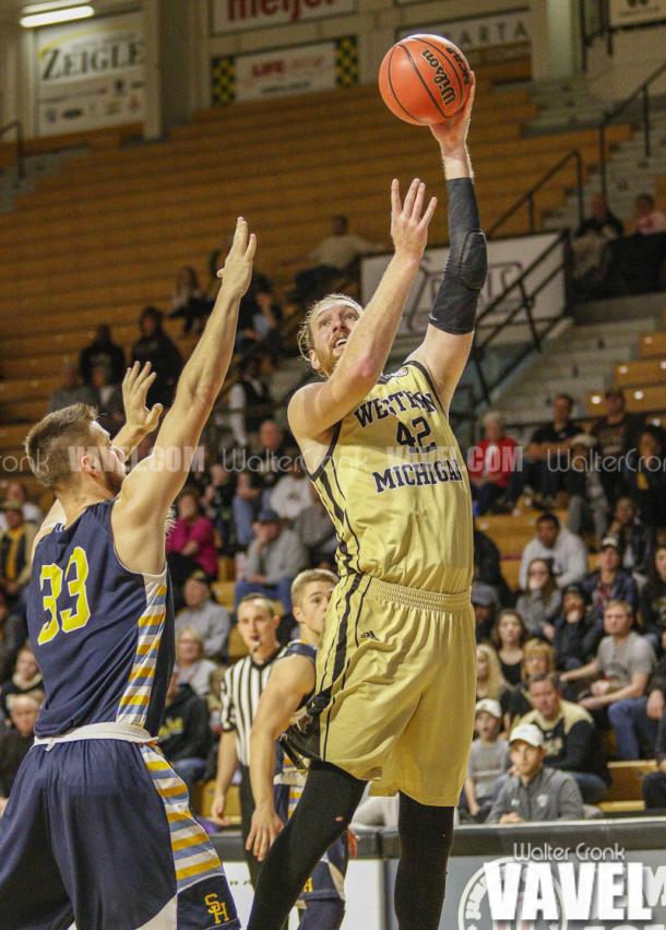 Drake LaMont (42) takes the hook shot over Trevor Holston (33). Photo: Walter Cronk