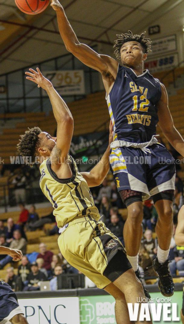 PJ Austin (12) blocks Michael Flowers (1) shot late in the game. Photo: Walter Cronk