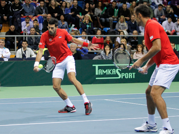 Novak Djokovic (L) and Nenad Zimonjic of Serbia in action against Marin Draganja and Franko Skugor of Croatia during their men's double match on the day two of the Davis Cup match between Serbia and Croatia on March 07, 2015 in Kraljevo, Serbia. (Photo by Srdjan Stevanovic/Getty Images)