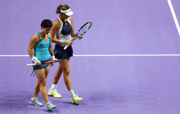 Carla Suarez Navarro and Garbine Muguruza of Spain speak on court during their doubles final match against Martina Hingis of Switzerland and Sania Mirza of India during the BNP Paribas WTA Finals at Singapore Sports Hub on November 1, 2015 in Singapore. (Photo by Clive Brunskill/Getty Images)