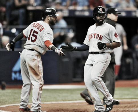 Jackie Bradley Jr. celebrates with Dustin Pedroia after crossing home in the eighth inning. | AP
