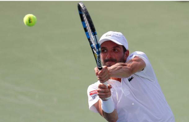 Benneteau reaches high for the backhand as a result of Verdasco's lefty-spin. Credit: 