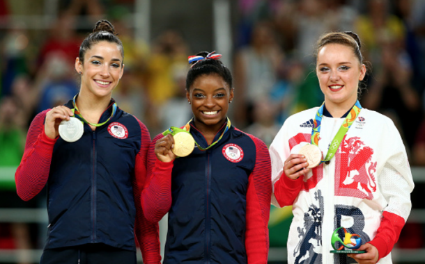 Raisman, Biles, and Tinkler celebrate their medals on the podium (Alex Livesey/Getty Images)