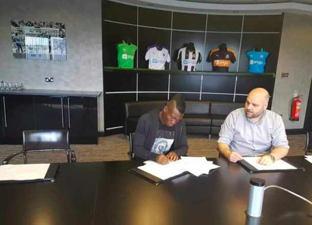 Atsu signing the paperwork needed to complete his loan spell to Newcastle (Photo: Twitter)