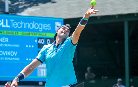 John Isner serves in his quarterfinal match against Dennis Novikov