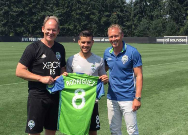 Victor Rodriguez with head coach Brian Schmetzer (L) and Vice President and Sporting Director Chris Henderson (R). | (Photo - Geoff Baker/Seattle Times)