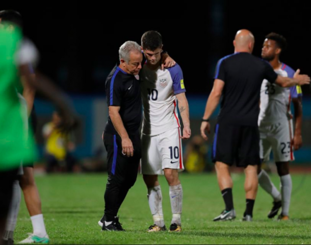 Christian Pulisic is comforted by coaches after the USMNT lost 2-1 to Trinidad and Tobago. | Photo: Rebecca Blackwell | AP