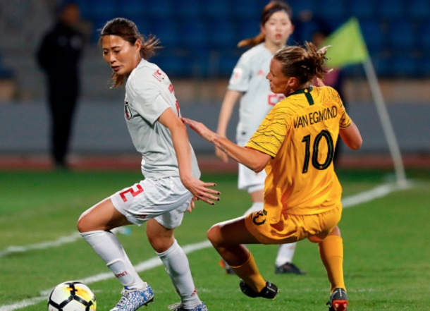 Seattle Reign FC and Japan defender Rumi Utsugi (Left) keeps the ball away from Orlando Pride and Australian midfielder Emily van Egmond. (Photo by JACK GUEZ/AFP/Getty Images)