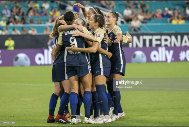 The Courage gather in a group hug after scoring a goal during the final ICC game. Photo: Getty Images/Miami Herald