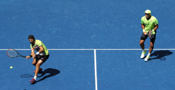 Jean-Julien Rojer hits a volley with partner Horia Tecau looking on (Phoot: Elsa/Getty Images)