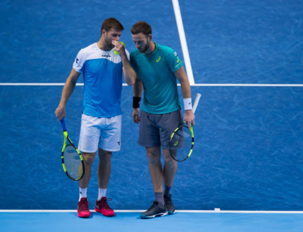 Ryan Harrison and Michael Venus talk tactics as they win the second set (Photo: Clive Brunskill/Getty Images)
