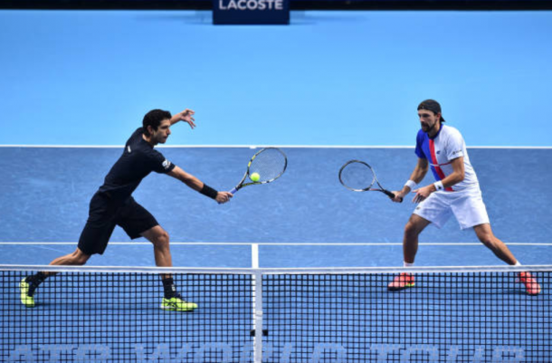 Marcelo Melo plays a volley with Lukasz Kubot looking on (Photo: Glyn Kirk/Getty Images)