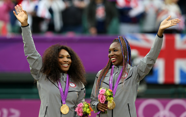 Serena and Venus Williams wave to the crowd after receiving their gold medals during the women's doubles prize ceremony at the 2012 London Olympics.