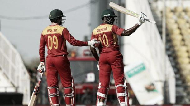 Sibanda raises his bat after scoring 50 on the opening day (photo: AFP)