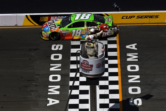  Kyle Busch, driver of the #18 M&M's Crispy Toyota, crosses the finish line to win the NASCAR Sprint Cup Series Toyota/Save Mart 350 at Sonoma Raceway on June 28, 2015 in Sonoma, California. Jonathan Moore/Getty Images