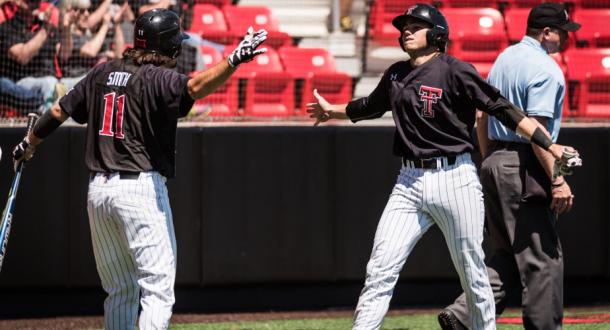 Stephen Smith and Michael high five each other during their 3-2 victory over Florida Gators in the College World Series | Photo Courtesy: Texas Tech Athletics